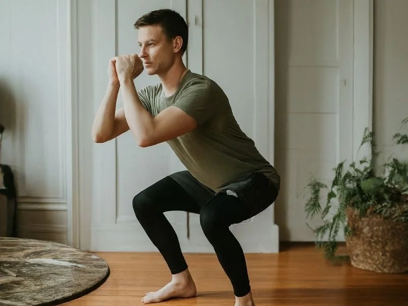 A person doing a bodyweight squat at home