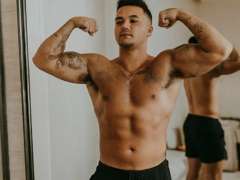 A person flexing their muscles in front of a mirror, looking proud and confident