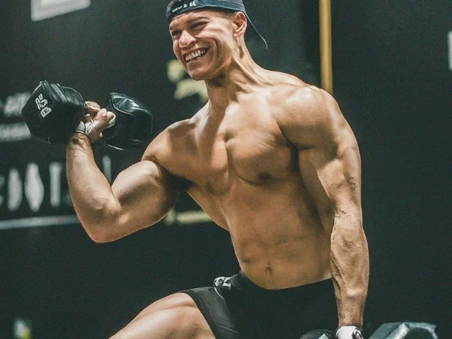 A person lifting weights, smiling and looking strong