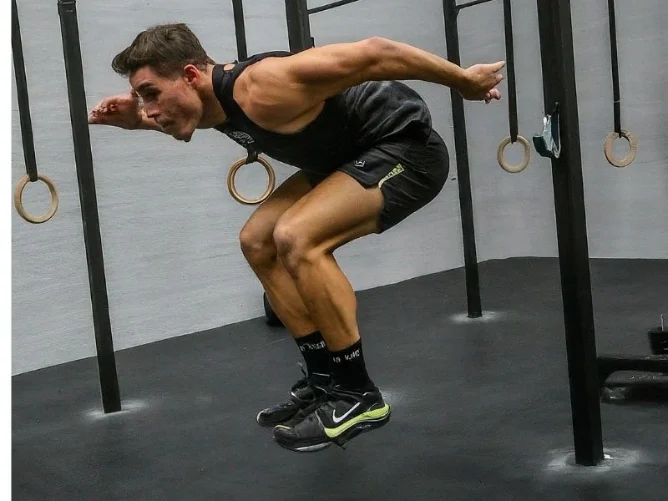 A person performing a HIIT workout, such as burpees or jumping jacks