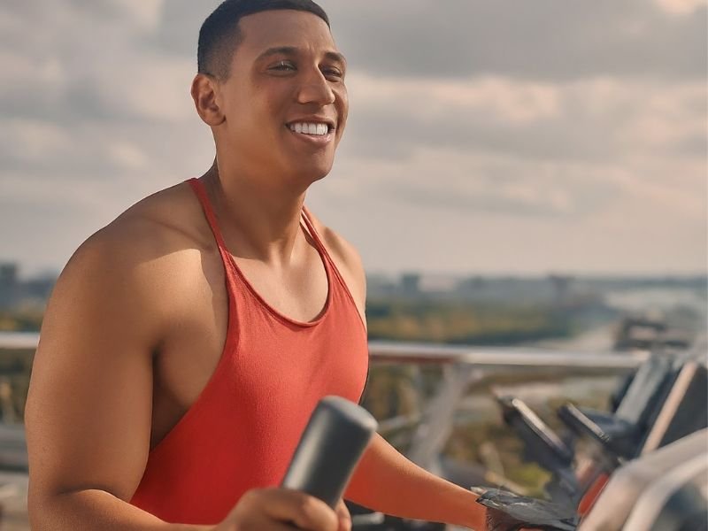 A person smiling and looking joyful while doing cardio exercise