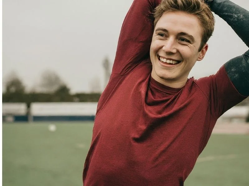 A person stretching and smiling before a workout
