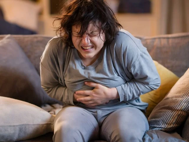 an individual clutching their stomach,