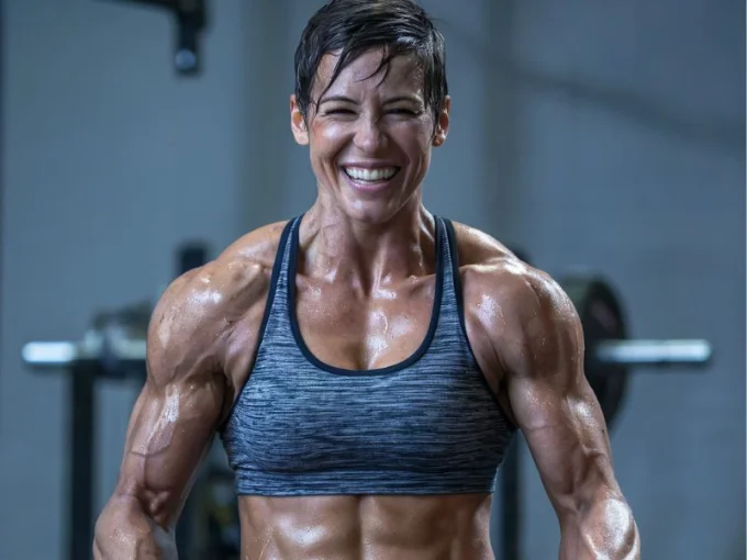 A photo of a fit and energized athlete smiling triumphantly after a successful workout