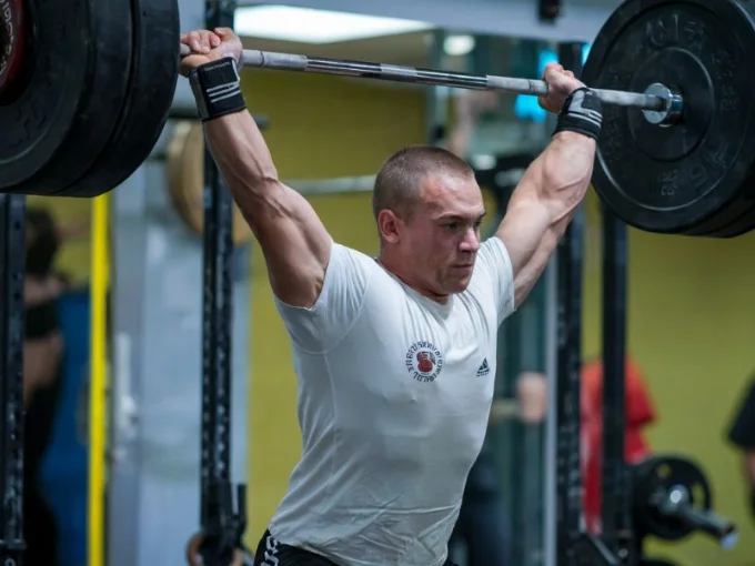 A photo of a weightlifter performing a heavy lift at a gym