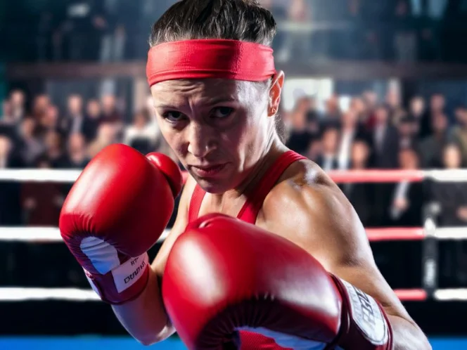 A photo of a woman performing boxing. She is wearing red gloves and a red headband