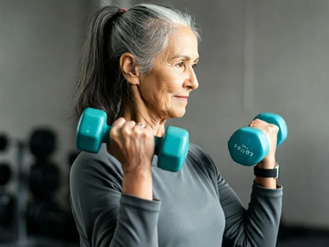 A senior lifting light dumbbells with proper form