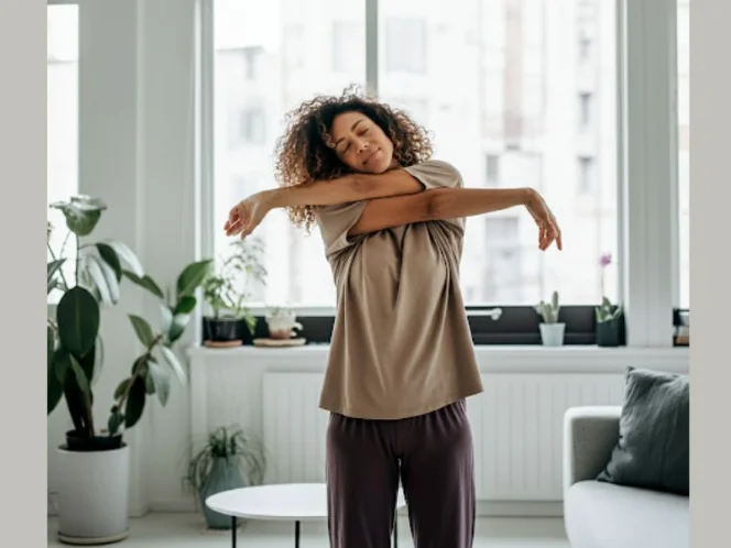 A person exercising comfortably in their living room, wearing relaxed clothing