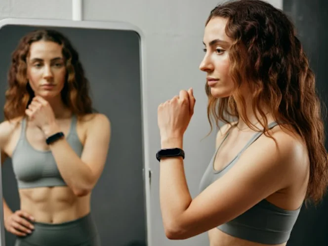 A person looking at themselves in the mirror, contemplating their health and fitness goals