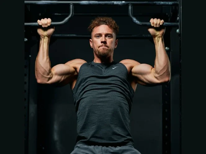 A person performing a pull-up with an overhand grip, demonstrating good technique and control