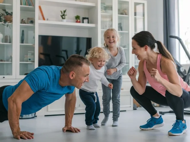 A family exercising together in their living room, having fun and encouraging each other